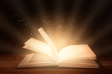 Open book on table against dark background