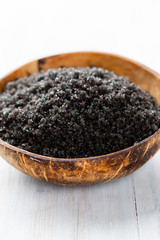 Sea salt in bowl, aroma oil in bottles, Wellness and flowers on grey textured background and flowers on vintage wooden background. Selective focus.