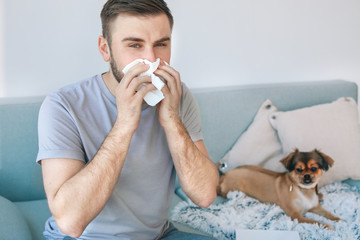 Man suffering from pet allergy at home