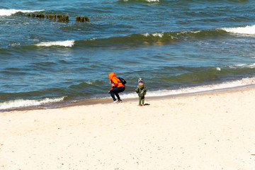 young mother with a child playing on the beach