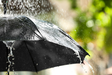 Black umbrella outdoors on rainy day