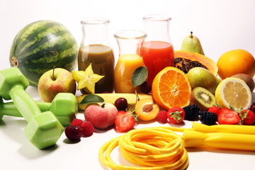 Healthy lifestyle concept. healthy fruits, smoothies and sport fitness equipment, dumbbells and jumping rope