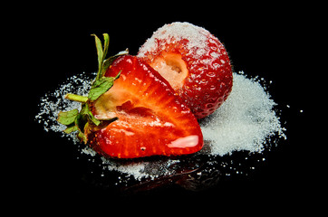 Ripe delicious strawberry with sugar isolated on black background