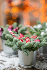 Beautiful festive set. Small arrangements of fresh spruce, pink ornamentals in a rustic wooden box. Christmas mood. Garland bokeh on background. Bokeh of Garland lights on background.