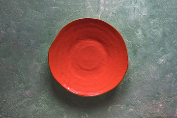 Orange ceramic plate handmade on a mother-of-pearl background