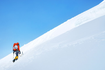 Fototapeta na wymiar Mountaneer climbs a snowy ridge in Mont Blanc, France. Enterprise, diligence, team work: mountaneering concepts.
