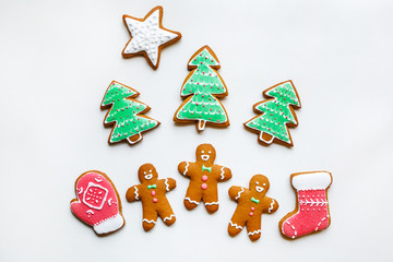 Handmade festive gingerbread cookies in the form of stars, snowflakes, people, socks, staff, mittens, Christmas trees, hearts for xmas and new year holiday on white paper background