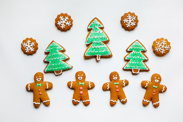 Handmade festive gingerbread cookies in the form of stars, snowflakes, people, socks, staff, mittens, Christmas trees, hearts for xmas and new year holiday on white paper background