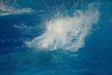 Powerful splash on a blue water surface with waves and splashes.