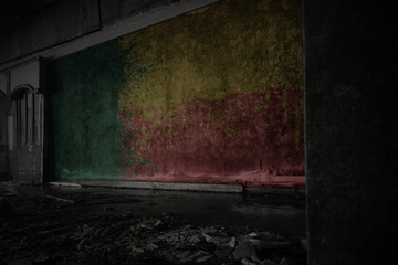 painted flag of benin on the dirty old wall in an abandoned ruined house.