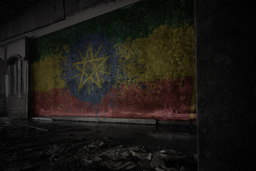 Fototapeta na wymiar painted flag of ethiopia on the dirty old wall in an abandoned ruined house.