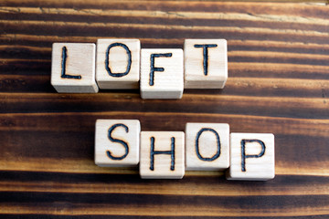 word loft shop wooden cubes letters, on a dark wooden burnt background