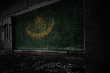 painted flag of mauritania on the dirty old wall in an abandoned ruined house.