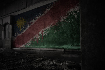 painted flag of namibia on the dirty old wall in an abandoned ruined house.