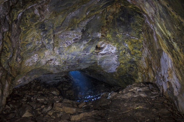 Fototapeta na wymiar A ray of light penetrates a hole in an underground mine