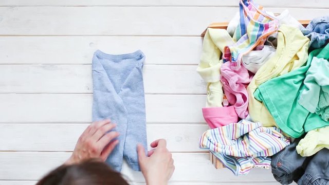 Marie Kondo tyding up method concept - folding kids clothes, top view