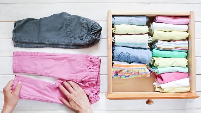 Marie Kondo tyding up method concept - folding kids clothes, top view