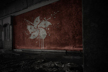 painted flag of hong kong on the dirty old wall in an abandoned ruined house.