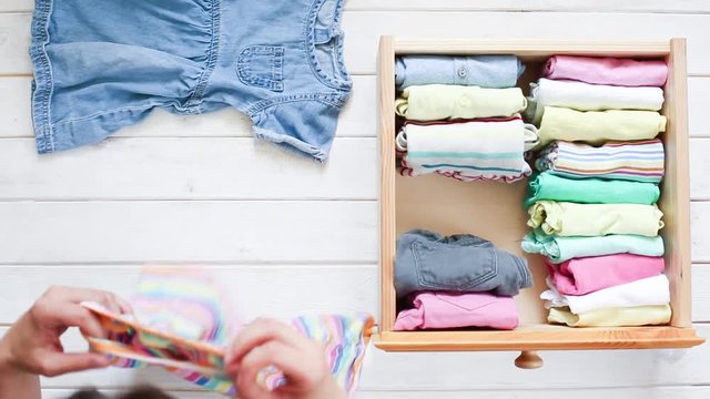 Marie Kondo tyding up method concept - folding kids clothes, top view