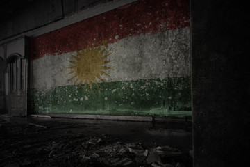 painted flag of kurdistan on the dirty old wall in an abandoned ruined house.