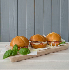 Three buns with raw minced pork - mett, on gray-white wooden background