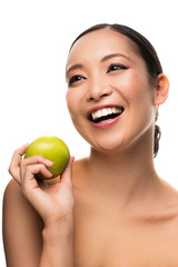 attractive asian girl laughing and holding green apple, isolated on white