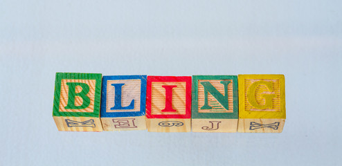The term bling visually displayed in colored toy blocks on a clear background image with copy space...
