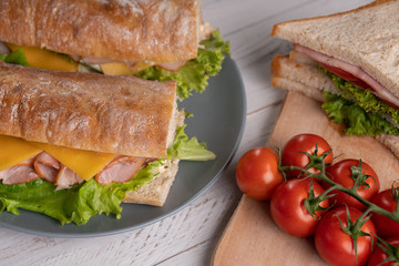 Homemade breakfast. Traditional morning food. Lunch. Delicious fresh sandwich, baguette, toast with tomatoes. White table. Kitchen