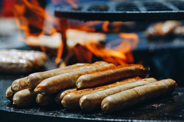 appetizing juicy chicken sausages on the grill close-up