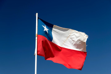 Naklejka na ściany i meble Chilean flag waving under blue sky