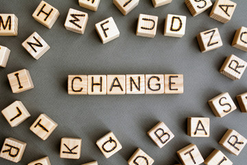 the word change wooden cubes with burnt letters, improvement or worsening of career growth gray background top view, scattered cubes around random letters