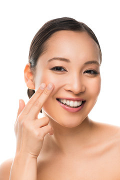 beautiful smiling asian girl applying cream, isolated on white