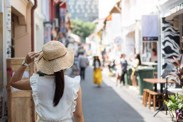 Young woman traveling with white dress and hat, happy Asian traveler walking at Haji Lane and Arab...