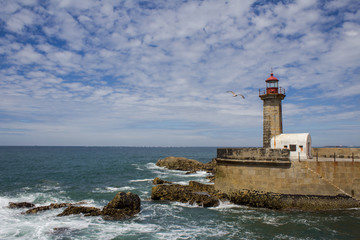 Fototapeta na wymiar Beautiful Felgueiras Lighthouse on Atlantic Ocean in Porto, Portugal. Beach do Carneiro.