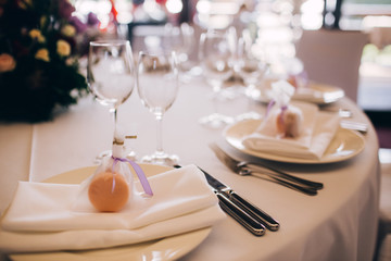 Round white table with elegant compositions from natural flowers. Banquet at the luxury wedding. Elegant design wedding table.