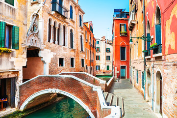 Scenic canal with bridge and colorful architecture in Venice, Italy. Famous travel destination