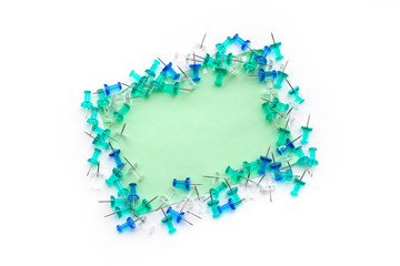 Blue, turquoise and transparent buttons laid out on note paper, on an isolated white background, with space for text, top view.