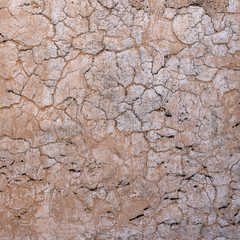 Cracked concrete old wall covered with beige cement surface as background. Textured background old cracked wall