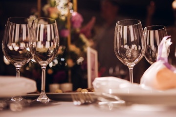 Round white table with elegant compositions from natural flowers. Banquet at the luxury wedding. Elegant design wedding table.