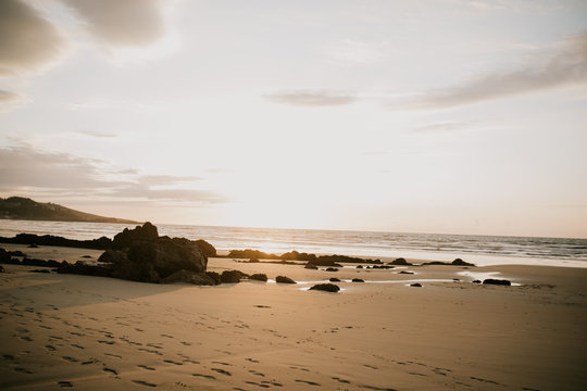lonely bach with sunset and rocks