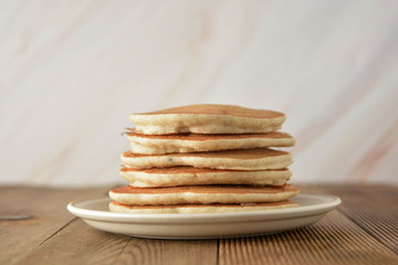 Stack of pancakes on wooden background. Homemade american pancakes, isolated.