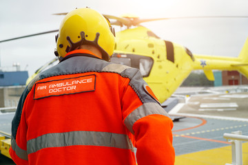 Doctor of an air ambulance runs to a rescue helicopter for an emergency operation