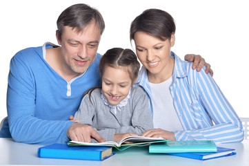 Happy parents and daughter doing homework on white background