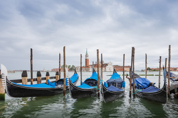 Gondolas parked in Venice, Italy. View of the Venetian Lagoon in the rain