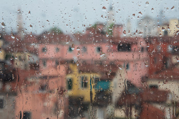 Blurred view of Venice on a rainy day through the old venetian glass window with raindrops of the Doge's palace