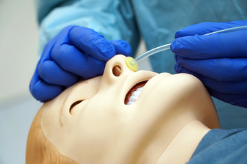 Doctor shows the use of a nasal oxygen cannula using a medical patient simulator in the operating room of a hospital