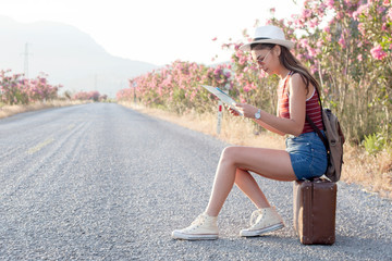 young beautiful woman waiting for car at the road trip