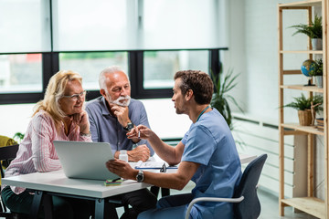 Happy senior couple having consultations with their doctor at his office.