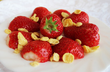 Beautiful cultivated deep red delicious strawberries, macro photography, decoration with fruit in white plate with peaces and beautiful rose flower