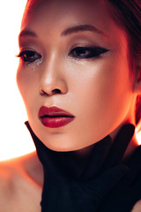 Fototapeta na wymiar asian model in black gloves in red light, isolated on white